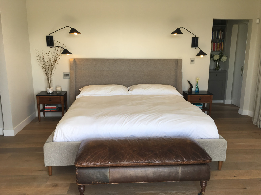 Ejemplo de dormitorio principal y abovedado minimalista de tamaño medio sin chimenea con paredes blancas, suelo de madera clara y suelo multicolor