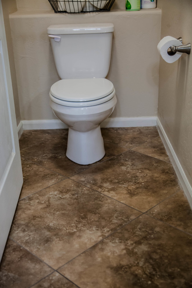 Large transitional master ceramic tile drop-in bathtub photo in Phoenix with raised-panel cabinets, light wood cabinets, beige walls, an undermount sink and granite countertops