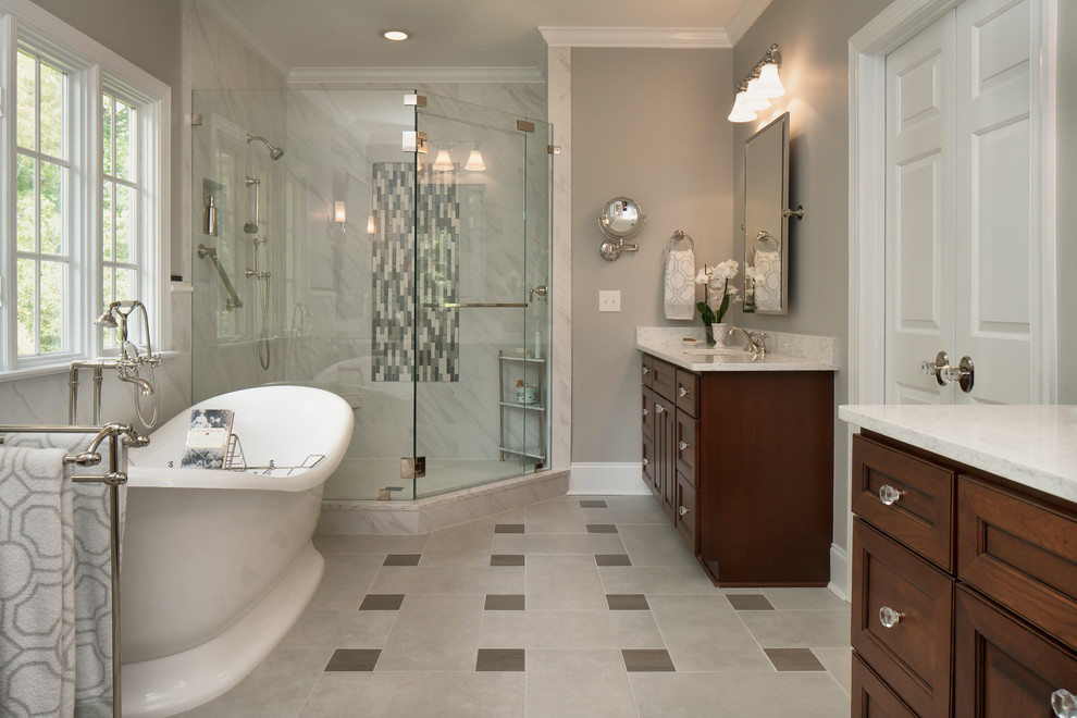 Bathroom - mid-sized traditional master gray tile and porcelain tile porcelain tile and gray floor bathroom idea in Charlotte with raised-panel cabinets, dark wood cabinets, a two-piece toilet, gray walls, an undermount sink, quartz countertops and a hinged shower door