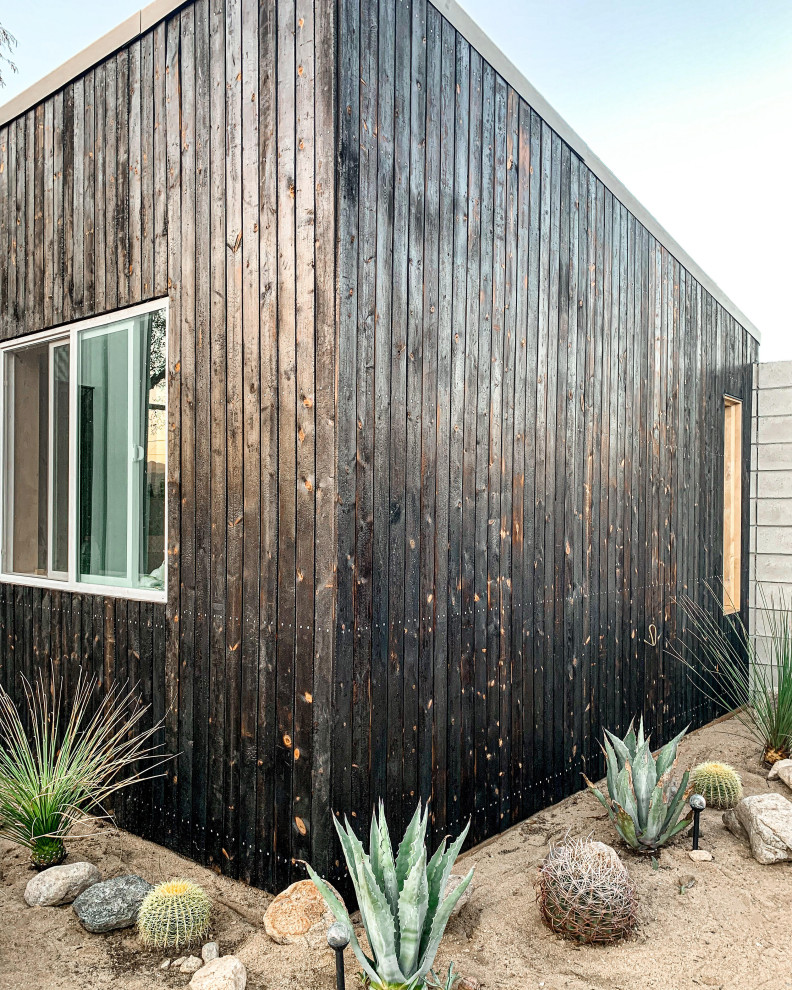 Ispirazione per la facciata di una casa piccola nera moderna a un piano con rivestimento in legno, copertura a scandole e tetto nero