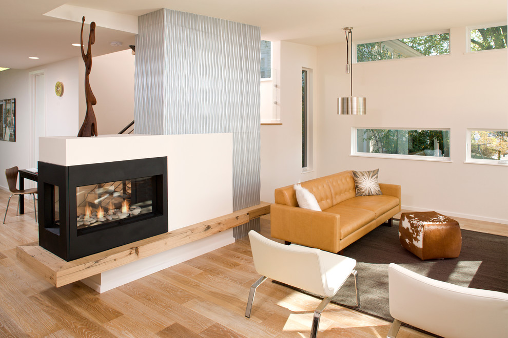This is an example of a mid-sized scandinavian formal open concept living room in Minneapolis with white walls, light hardwood floors, a two-sided fireplace, a metal fireplace surround, no tv and brown floor.