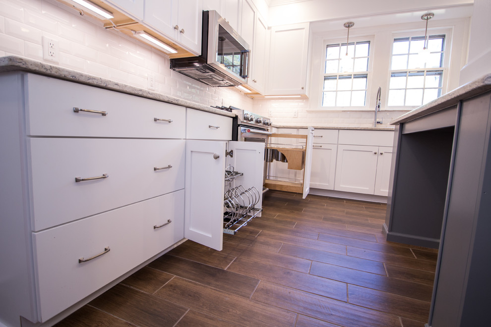 Eat-in kitchen - small u-shaped ceramic tile eat-in kitchen idea with an undermount sink, shaker cabinets, white cabinets, quartz countertops, white backsplash, subway tile backsplash, stainless steel appliances, an island and white countertops