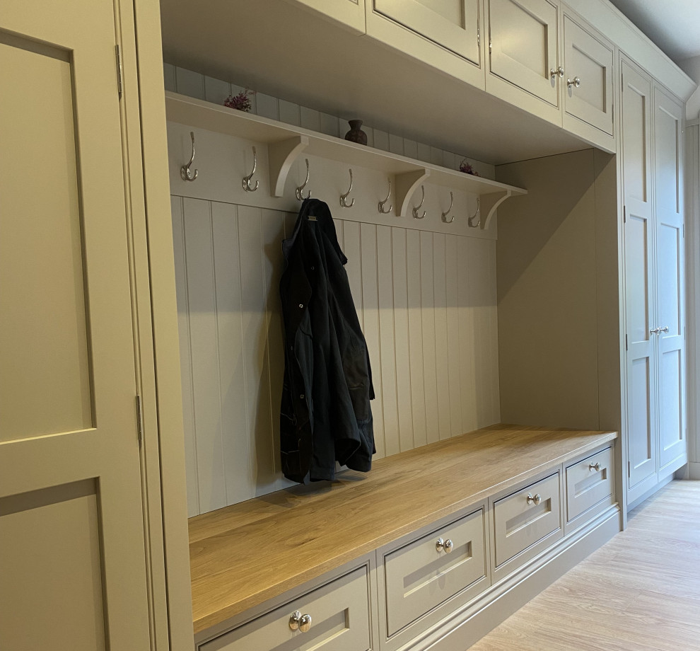 Photo of a mid-sized arts and crafts galley utility room in Sussex with a farmhouse sink, shaker cabinets, beige cabinets, white splashback, shiplap splashback, linoleum floors, brown floor and white benchtop.