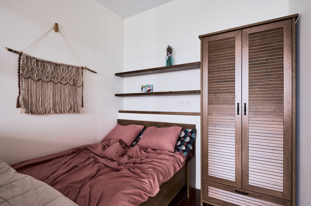 Идея дизайна: маленькая хозяйская спальня в белых тонах с отделкой деревом в скандинавском стиле с белыми стенами, темным паркетным полом, коричневым полом и кроватью в нише для на участке и в саду