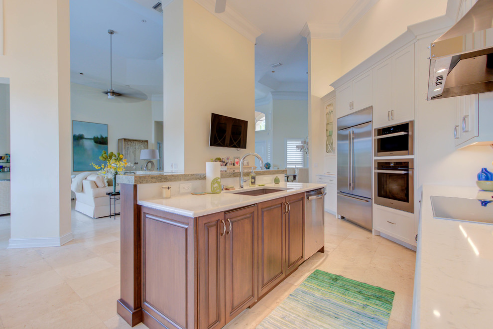 Example of a large transitional single-wall enclosed kitchen design with an undermount sink, flat-panel cabinets, white cabinets, quartz countertops, blue backsplash, stone tile backsplash, stainless steel appliances and an island