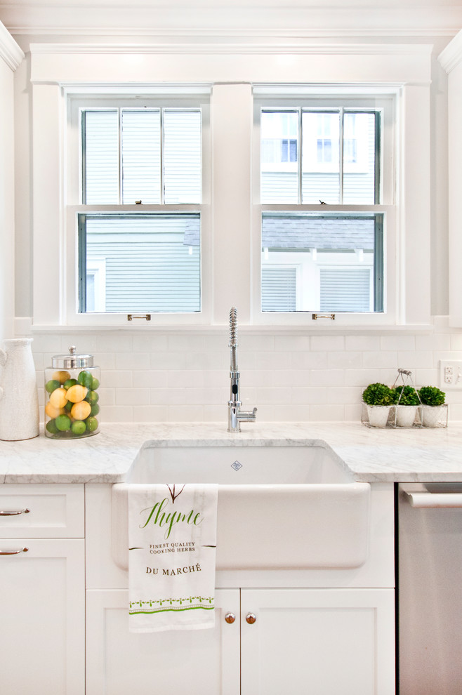 This is an example of a small transitional galley eat-in kitchen in Nashville with a farmhouse sink, shaker cabinets, white cabinets, marble benchtops, white splashback, subway tile splashback, stainless steel appliances, medium hardwood floors, no island, brown floor and multi-coloured benchtop.