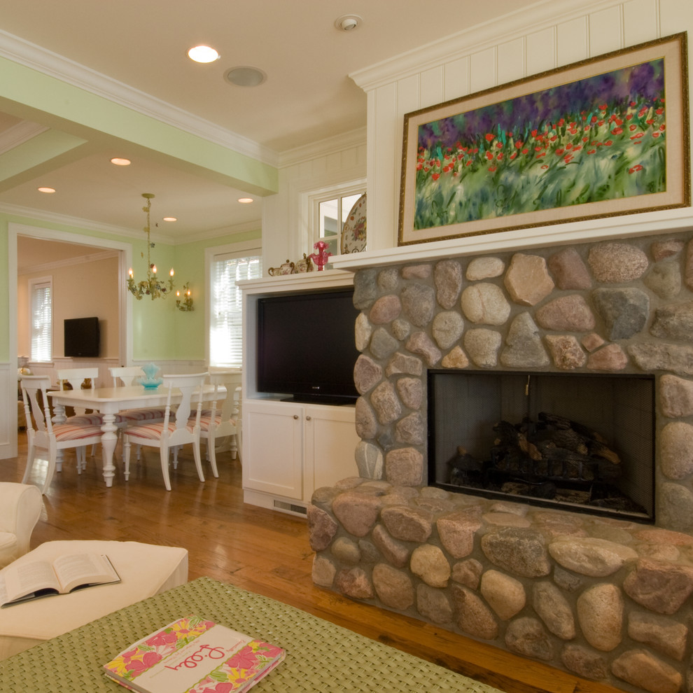 Design ideas for a mid-sized beach style enclosed family room in Other with green walls, a standard fireplace, a stone fireplace surround, medium hardwood floors and brown floor.
