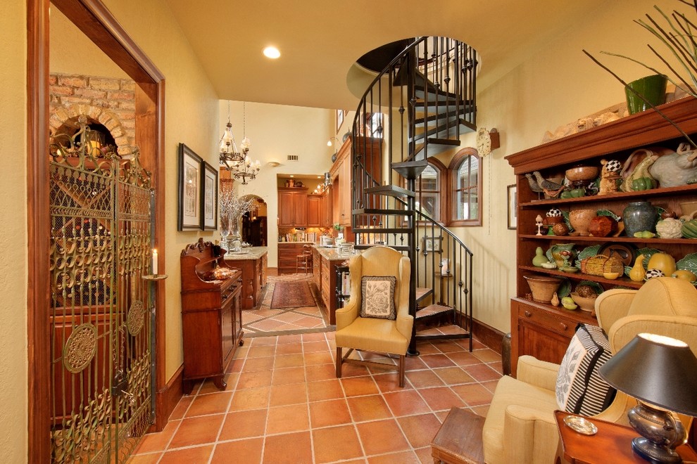 This is an example of a mediterranean terracotta spiral staircase in Houston with open risers and metal railing.