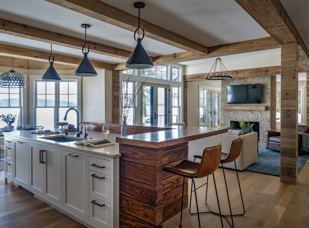 Design ideas for a country open plan kitchen in Boston with an undermount sink, shaker cabinets, white cabinets, medium hardwood floors, with island, brown floor and beige benchtop.
