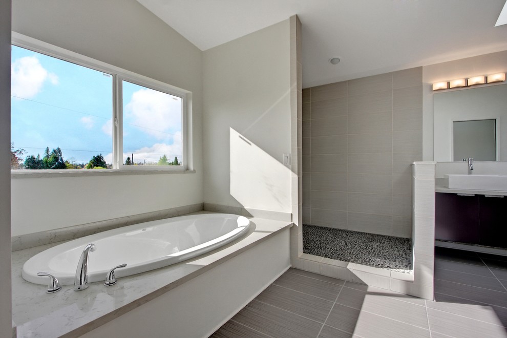 Design ideas for a large modern master bathroom in Seattle with flat-panel cabinets, dark wood cabinets, a drop-in tub and gray tile.