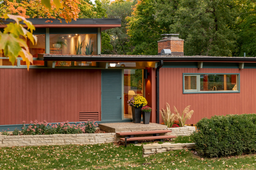 This is an example of a medium sized and multi-coloured retro split-level detached house in Minneapolis with wood cladding and a flat roof.