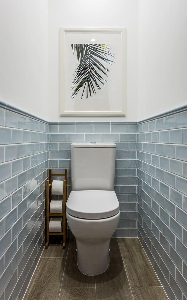 Design ideas for a beach style powder room in Malaga with blue tile, ceramic tile, ceramic floors, a two-piece toilet and white walls.