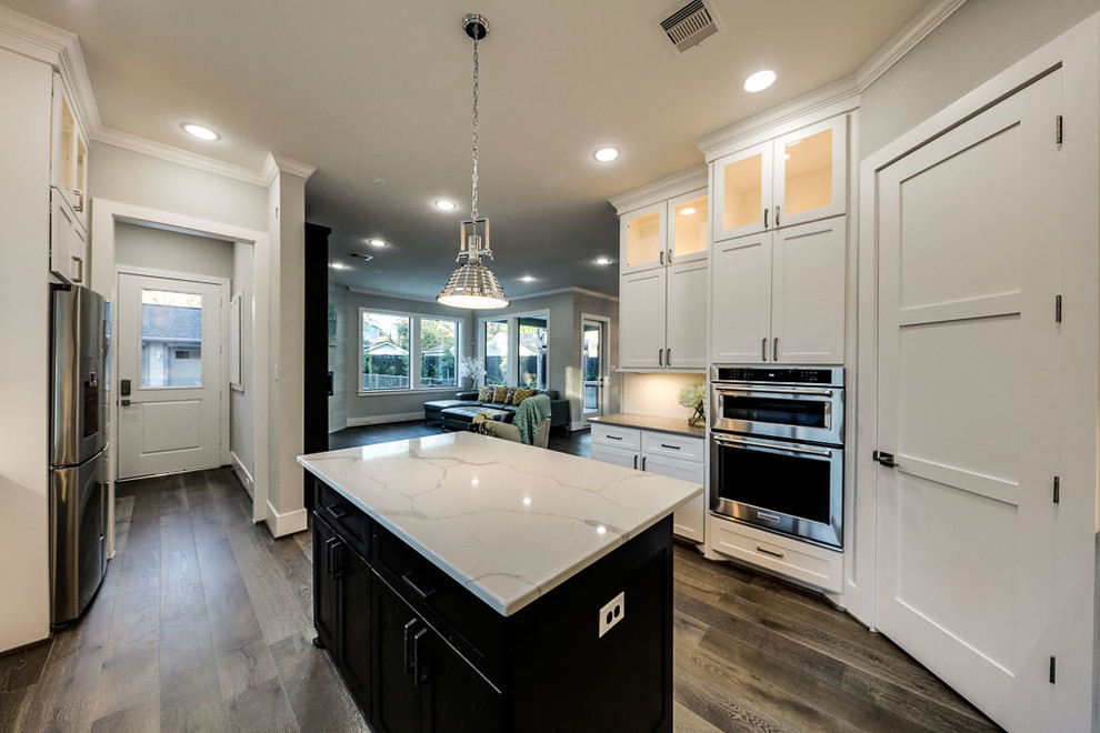 Inspiration for a large transitional u-shaped open plan kitchen in Houston with a farmhouse sink, shaker cabinets, white cabinets, quartzite benchtops, white splashback, porcelain splashback, stainless steel appliances, vinyl floors and with island.
