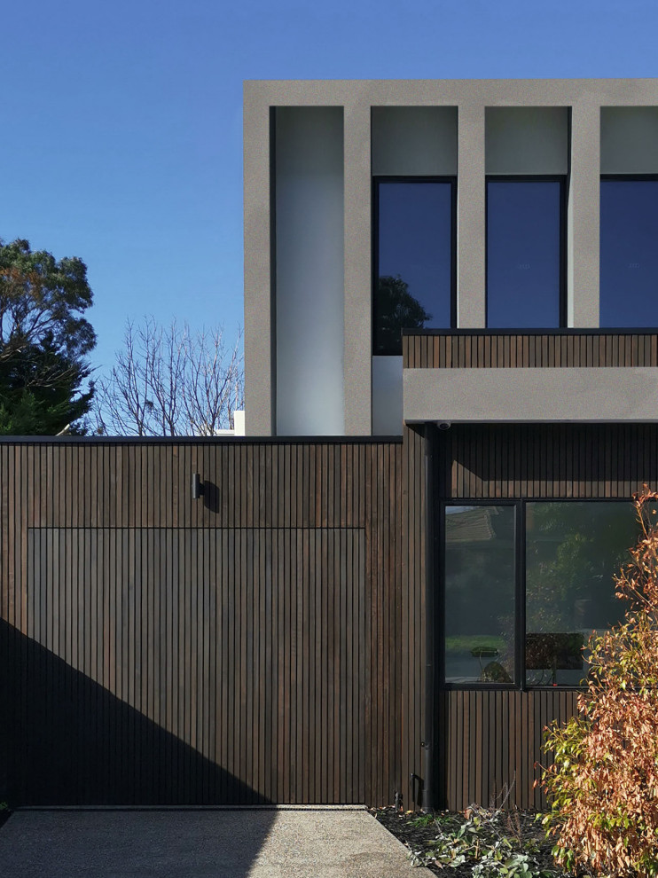 Ejemplo de fachada de casa bifamiliar marrón actual de tamaño medio de dos plantas con revestimiento de madera, tejado plano y tejado de metal