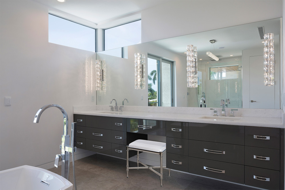 Design ideas for a mid-sized modern master bathroom in Miami with flat-panel cabinets, grey cabinets, a freestanding tub, a corner shower, a one-piece toilet, multi-coloured tile, marble, white walls, ceramic floors, an undermount sink, marble benchtops, brown floor, a hinged shower door and white benchtops.