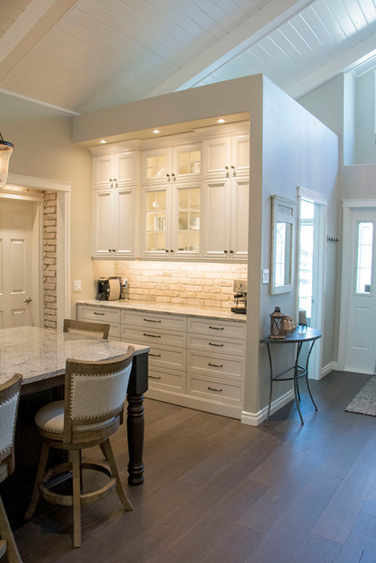 Inspiration for a large transitional l-shaped eat-in kitchen remodel with a double-bowl sink, shaker cabinets, white cabinets, beige backsplash, stainless steel appliances and an island