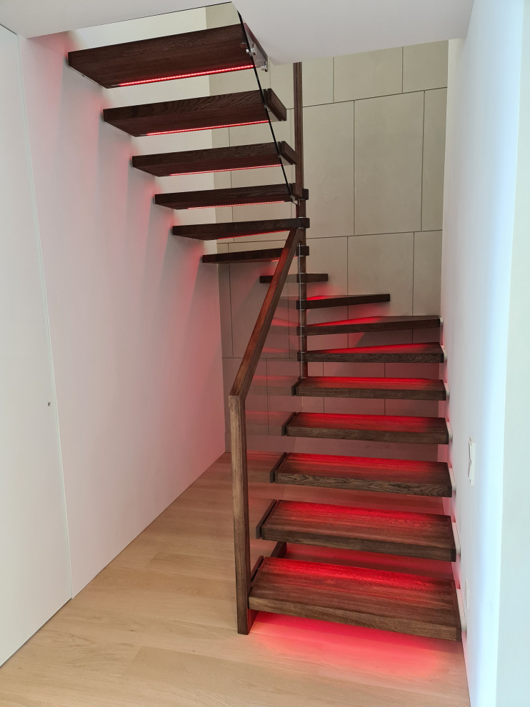 Идея дизайна: п-образная лестница среднего размера в современном стиле с деревянными ступенями и стеклянными перилами без подступенок