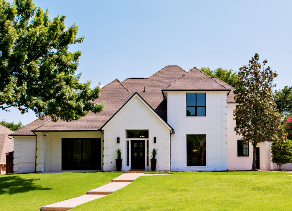 Photo of a small modern two-storey brick white house exterior in Dallas with a hip roof and a tile roof.
