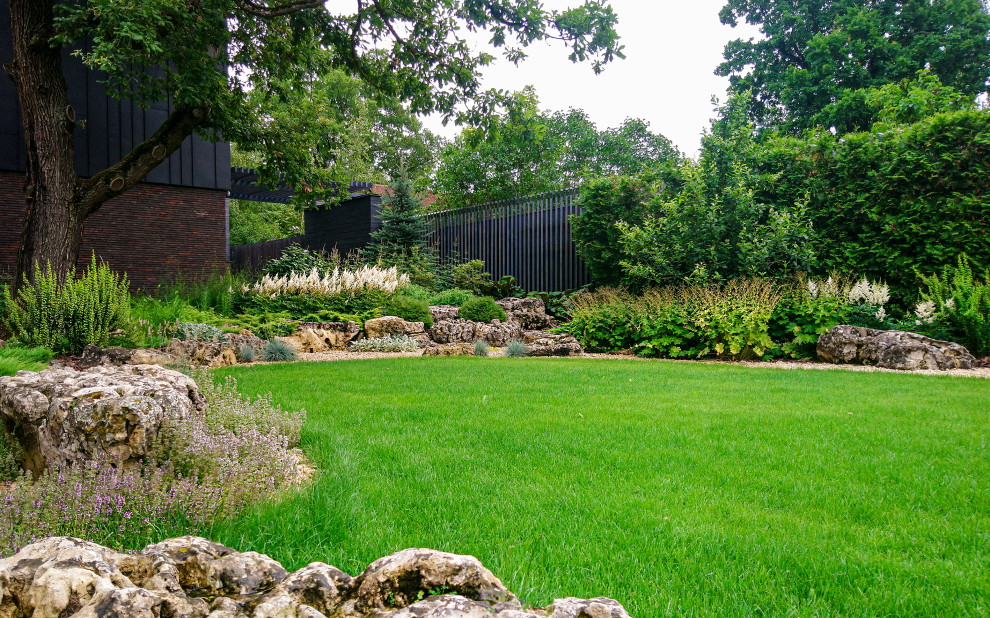 На фото: летний участок и сад среднего размера на заднем дворе в стиле лофт с камнем в ландшафтном дизайне и полуденной тенью