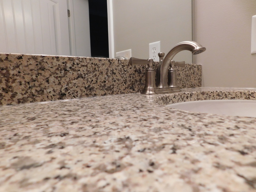 Home design - large transitional master gray tile and ceramic tile ceramic tile home design idea with raised-panel cabinets, medium tone wood cabinets, a two-piece toilet, beige walls, an undermount sink and granite countertops
