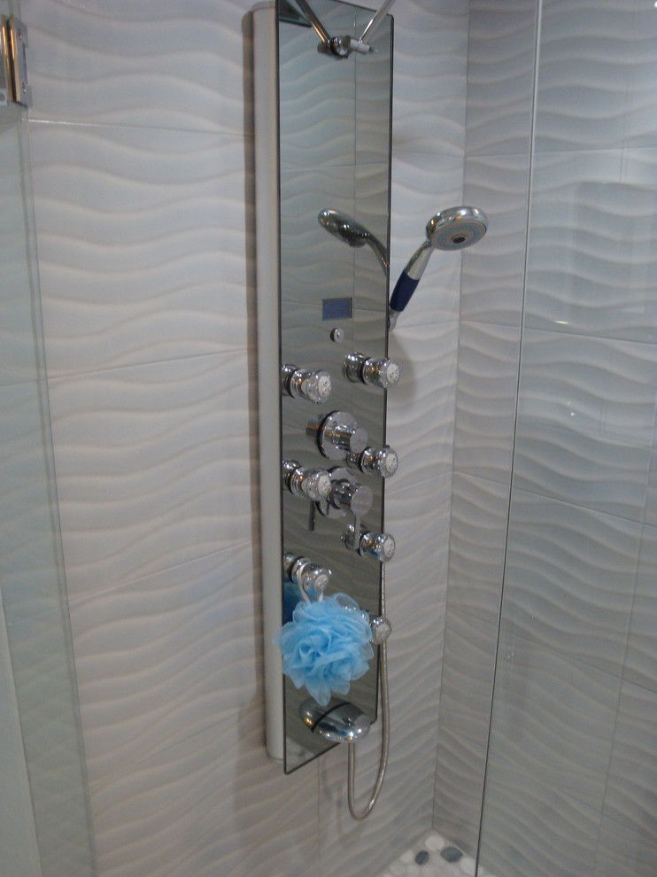 Photo of a small contemporary 3/4 bathroom in Miami with a double shower, blue tile, porcelain tile, pebble tile floors, multi-coloured floor and a hinged shower door.