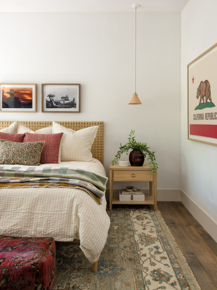 Inspiration for a mid-sized southwestern guest medium tone wood floor and brown floor bedroom remodel in Other with white walls