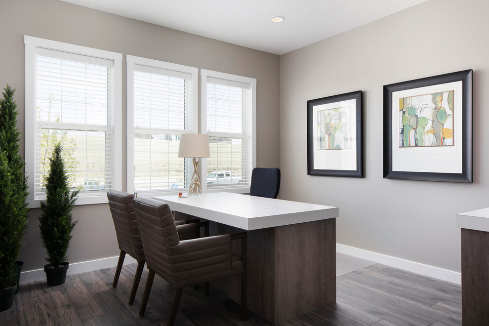 Inspiration for a mid-sized transitional home office in Calgary with grey walls, light hardwood floors and a freestanding desk.