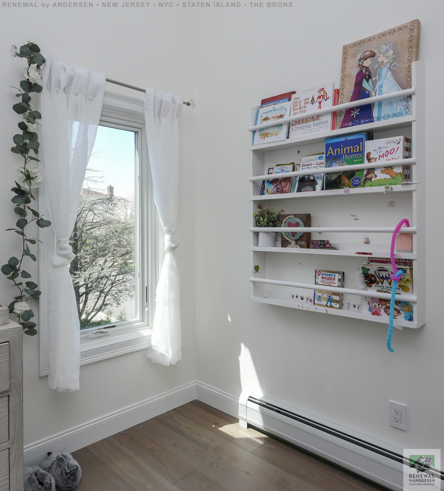 Inspiration for a large kids' bedroom for kids 4-10 years old and girls in New York with white walls, light hardwood floors, beige floor and vaulted.