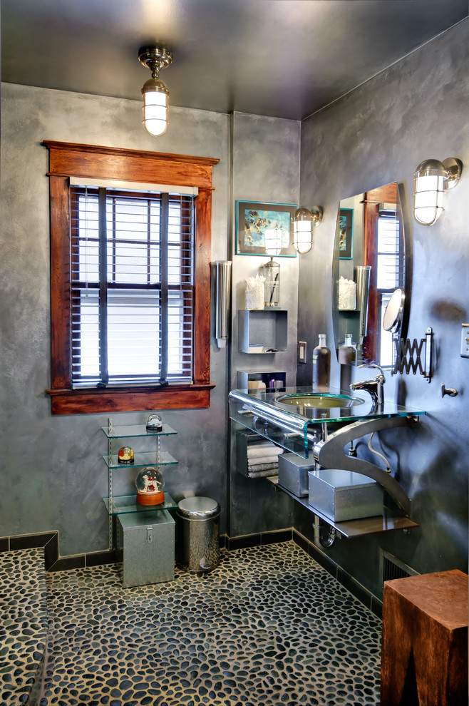 Inspiration for a mid-sized eclectic master bathroom in Philadelphia with an undermount sink, glass benchtops, pebble tile, grey walls, pebble tile floors, open cabinets, an alcove shower, a one-piece toilet, black tile and gray tile.