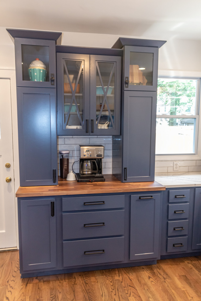 Small transitional u-shaped medium tone wood floor and brown floor eat-in kitchen photo in St Louis with an undermount sink, shaker cabinets, blue cabinets, quartz countertops, white backsplash, subway tile backsplash, stainless steel appliances and white countertops