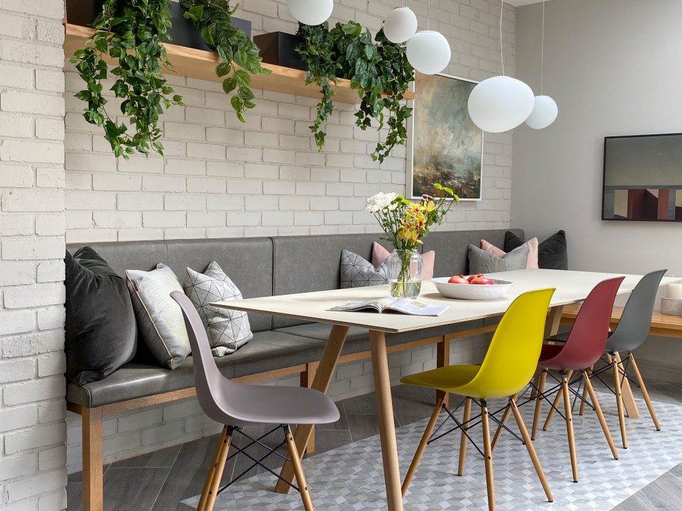 Inspiration for a large contemporary dining room in Other with white walls, grey floors and brick walls.