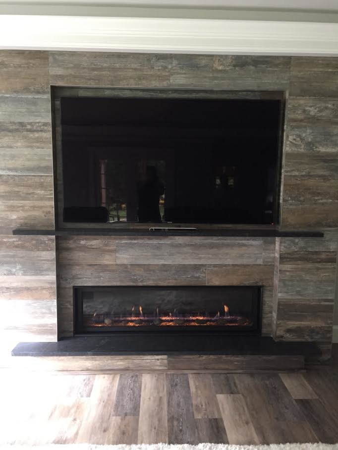 Inspiration for a mid-sized contemporary formal and enclosed medium tone wood floor and brown floor living room remodel in Boston with gray walls, a ribbon fireplace, a wood fireplace surround and a wall-mounted tv