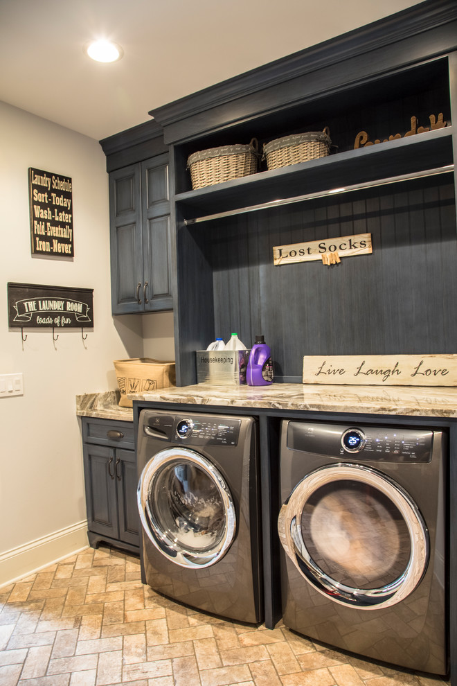 This is an example of a mid-sized country single-wall dedicated laundry room in Cleveland with raised-panel cabinets, blue cabinets, granite benchtops, beige walls, brick floors, a side-by-side washer and dryer, brown floor and brown benchtop.