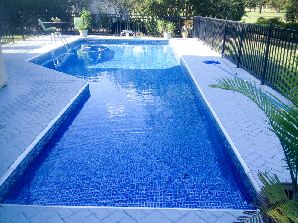 Example of a transitional backyard brick and custom-shaped natural pool design