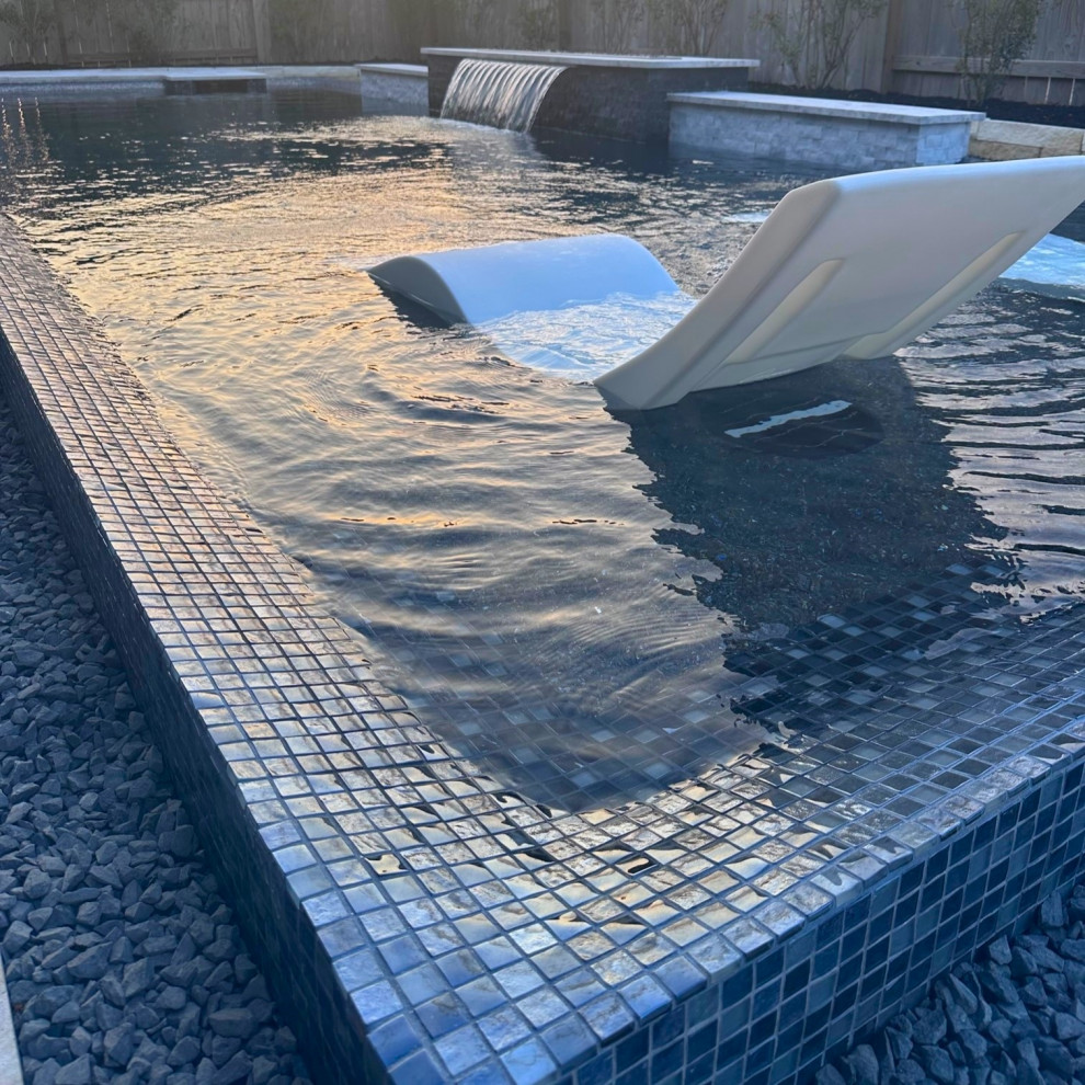 Photo of a modern l-shaped swimming pool in Houston with natural stone paving.