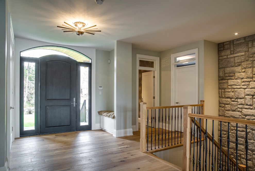 Mid-sized transitional light wood floor and brown floor front door photo with beige walls and a black front door