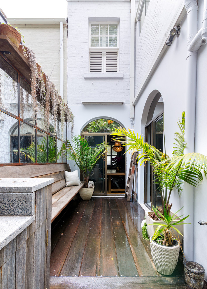 Inspiration for a tropical deck in Sydney with a container garden and no cover.