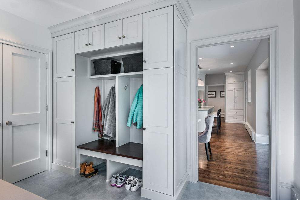 This is an example of a mid-sized transitional mudroom in Philadelphia with white walls, porcelain floors, a single front door, a white front door and grey floor.