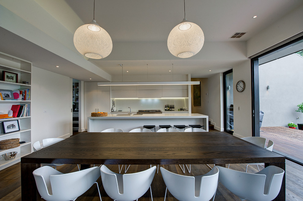 This is an example of a contemporary open plan dining in Melbourne with white walls and medium hardwood floors.