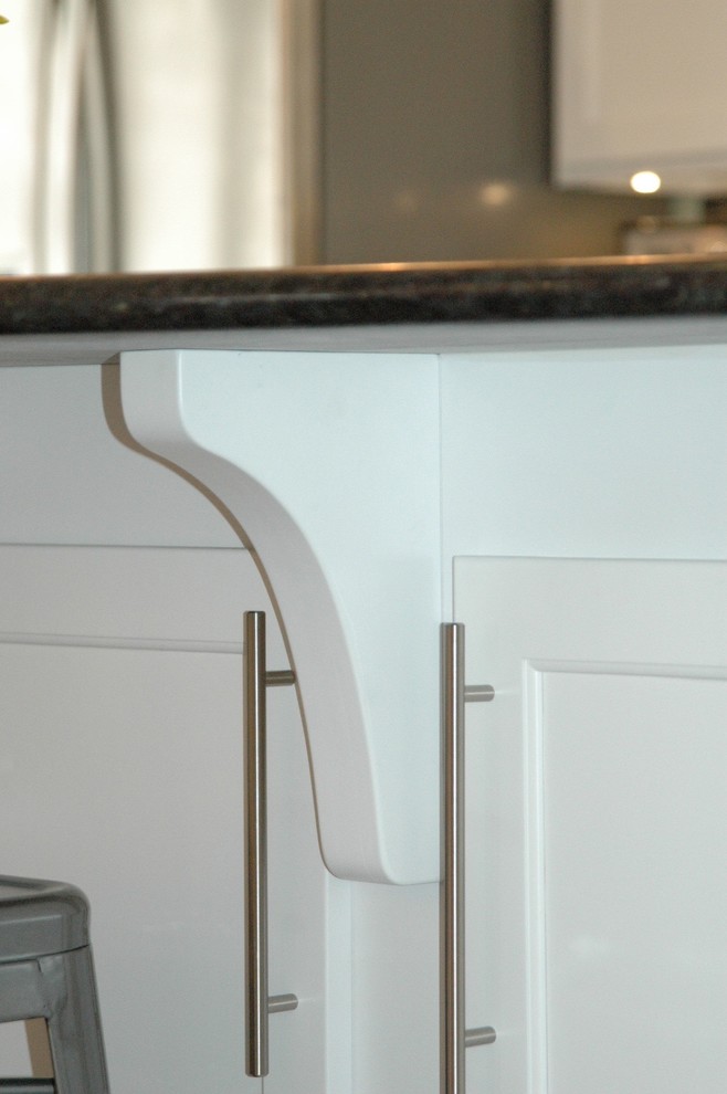 Inspiration for a mid-sized transitional l-shaped medium tone wood floor and brown floor enclosed kitchen remodel in Boston with an undermount sink, recessed-panel cabinets, white cabinets, granite countertops, multicolored backsplash, glass tile backsplash, stainless steel appliances and an island