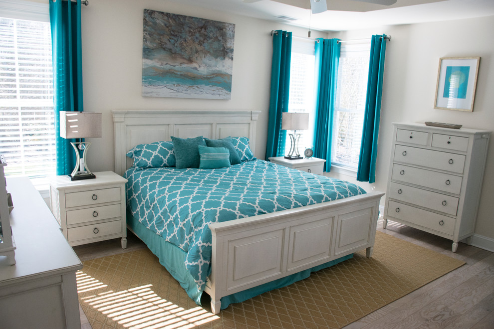 Design ideas for a beach style guest bedroom in Other with white walls, medium hardwood floors and grey floor.