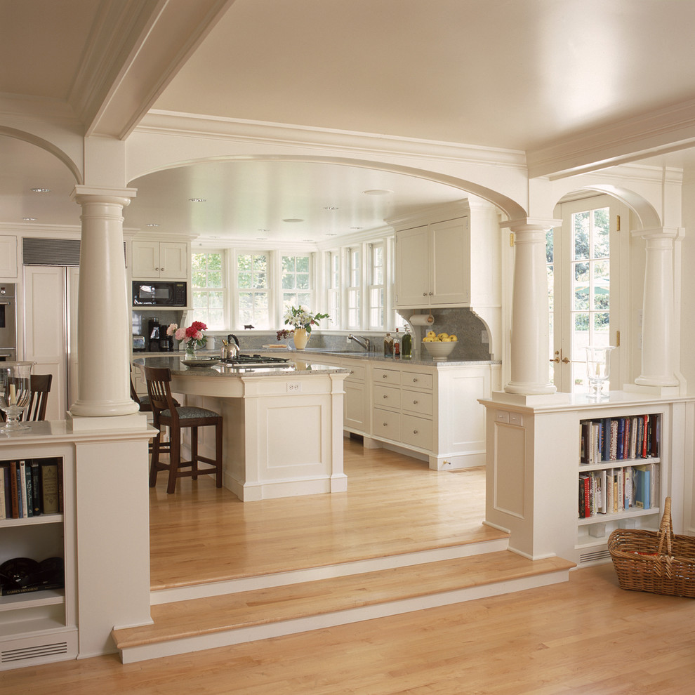 Traditional open plan kitchen in New York with recessed-panel cabinets, white cabinets and panelled appliances.