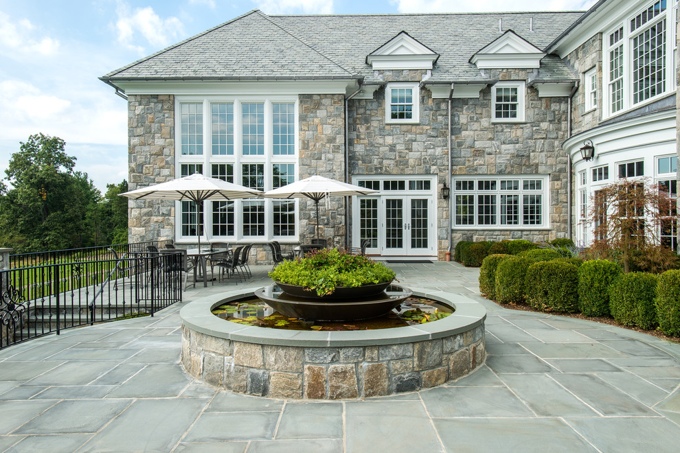 Traditional backyard patio in New York with a water feature, natural stone pavers and no cover.