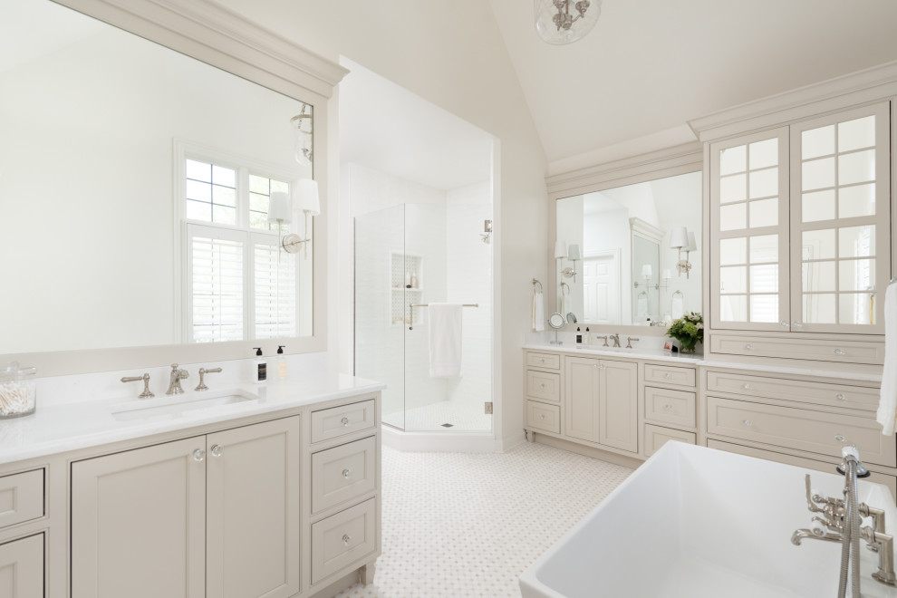 Photo of a large traditional master bathroom in Chicago with beaded inset cabinets, beige cabinets, a freestanding tub, a corner shower, white walls, marble floors, an undermount sink, engineered quartz benchtops, beige floor, a hinged shower door, white benchtops, a niche, a double vanity, a built-in vanity and vaulted.