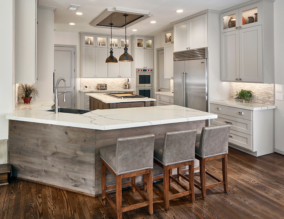 Design ideas for a large transitional eat-in kitchen in Dallas with a farmhouse sink, shaker cabinets, grey cabinets, multi-coloured splashback, stainless steel appliances, dark hardwood floors, a peninsula, brown floor and white benchtop.