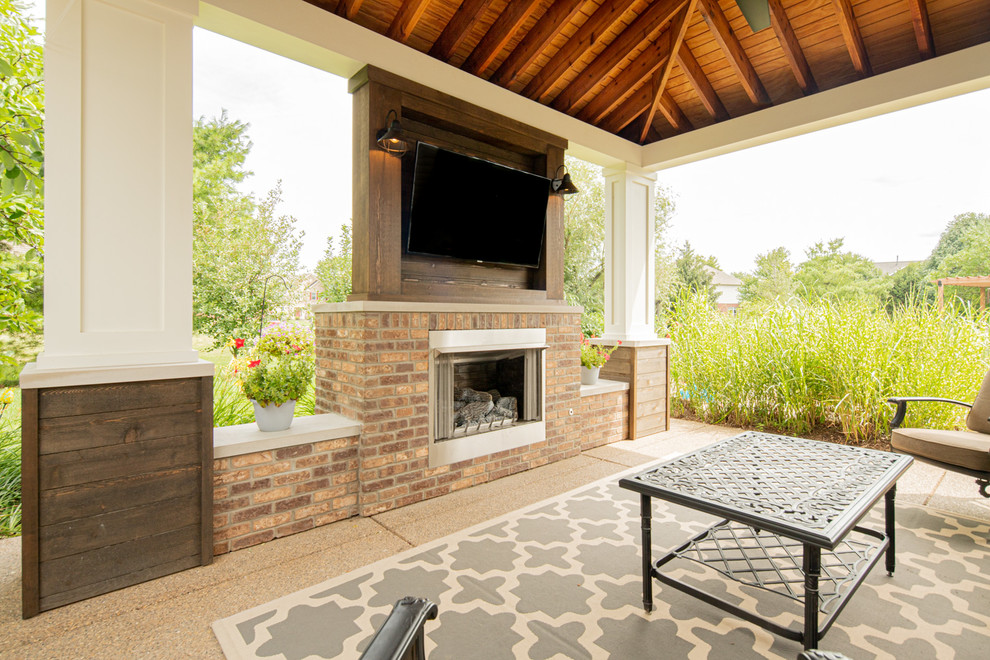 Inspiration for a mid-sized transitional side yard verandah in Indianapolis with with fireplace, concrete pavers and a pergola.
