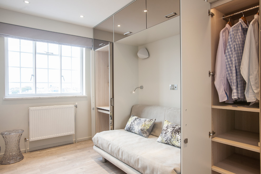 Photo of a small contemporary gender-neutral storage and wardrobe in London with vinyl floors and beige floor.