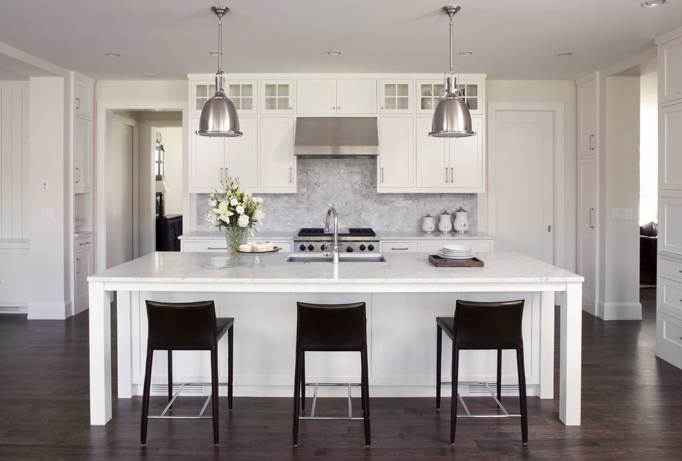 Design ideas for a traditional kitchen in Minneapolis with marble benchtops, stone tile splashback, stainless steel appliances, an undermount sink, recessed-panel cabinets, dark hardwood floors and grey splashback.