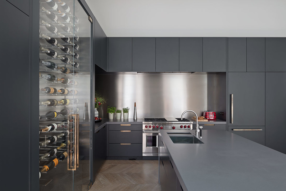 Design ideas for an expansive contemporary galley open plan kitchen in London with an undermount sink, glass-front cabinets, grey cabinets, solid surface benchtops, light hardwood floors, with island, brown floor and grey benchtop.