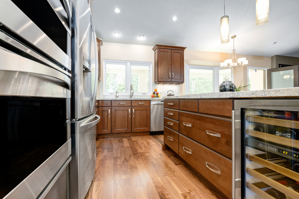 Example of a large transitional l-shaped light wood floor kitchen design in Phoenix with flat-panel cabinets, medium tone wood cabinets, quartz countertops, stainless steel appliances and an island